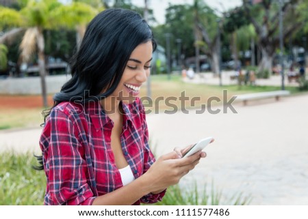 Native latin american woman receiving snapshot on phone outdoors in the city