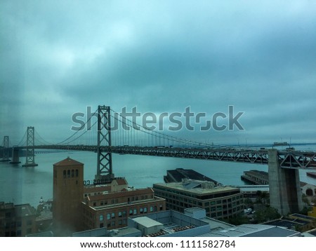 View of the Bay Bridge in San Francisco to Oakland, California, on a cloudy grey evening.