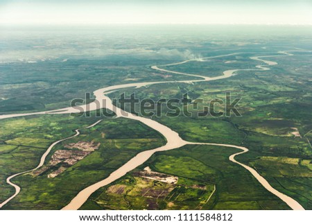 Landscape aerial view of colorful Amazon rivers, forest with trees, jungle, and fields