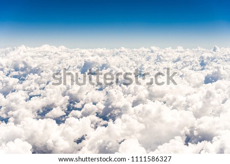 Abstract skyline background with white cumulus clouds against blue sky, aerial photography