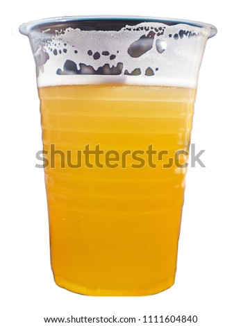 glass of cold and delicious beer with lush foam poured into a disposable plastic glass