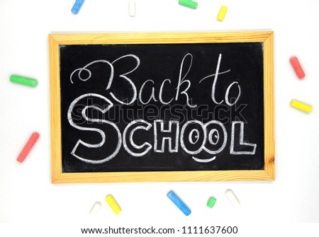 Back to school chalk lettering on blackboard with art supplies. Back to school banner template. School supplies composition. Chalkboard and color chalk on white background. Back to school with smile