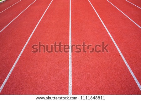 White lines of stadium and texture of running racetrack red rubber racetracks in outdoor stadium are 8 track and green grass field,empty athletics stadium with track,football field, soccer field.