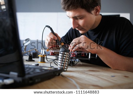 Picture of engineer with soldering iron repairing mechanism