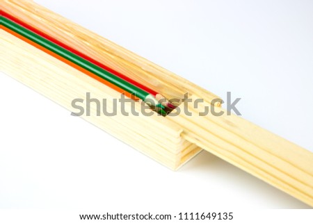 Wooden box, put a pencil and measure centimeters and inches placed isolated on a white background