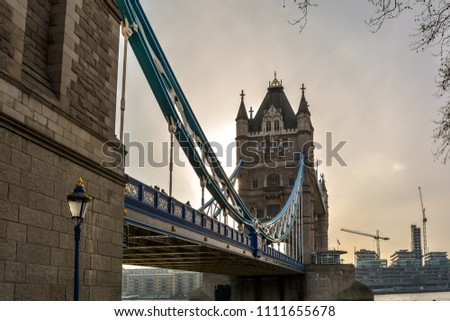 Low angle view of the Tower bridge, London with vintage street lamp. The bascule and suspension bridge crosses the River Thames and has become an iconic symbol of London.