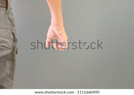 Expression gesture of an elderly man's hand on a gray background.