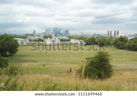 Panoramic view from the top of the old Greenwich Park to the University, the Queen's House, the National Maritime Museum; in the distance, cityscape with skyscrapers of Canary Wharf (London, UK)
