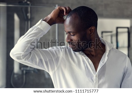 handsome young man in white shirt looking at his wet armpits Royalty-Free Stock Photo #1111715777