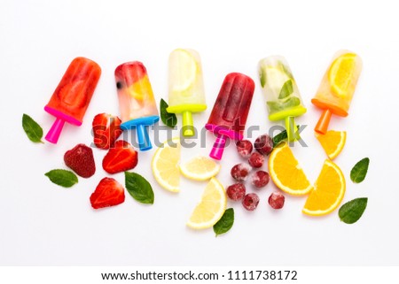 Homemade Multicolored bright fruit popsicle with strawberry, cherry, lemon, orange, lemon and mint and slices of fresh fruit on a light white background. Flat lay, top view.