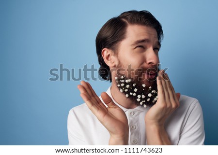  cute man with flowers in his beard on a blue background                              