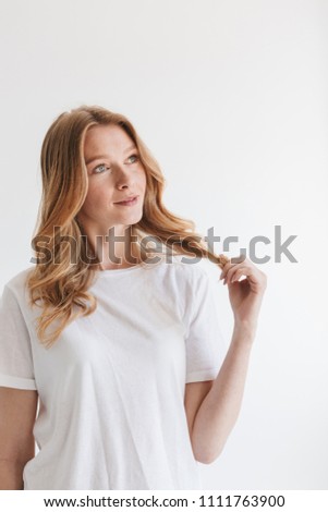 Image of amazing young cute redhead woman standing isolated over white wall background looking aside.