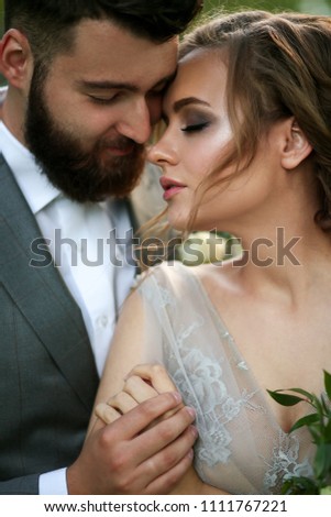 the groom in a gray suit and the bride in a gray dress look at each other, closeup portrait Royalty-Free Stock Photo #1111767221