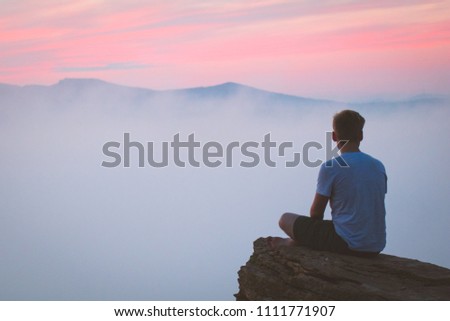 Dramatic sit on mountain with fogy sunrise yoga position