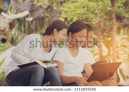 a group of people,family using mobile phone, computer notebook,reading book together with fun and happy on holiday.