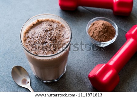 Chocolate Protein Shake Smoothie with Whey Protein Powder and Red Dumbbells. Sports Drink Royalty-Free Stock Photo #1111871813
