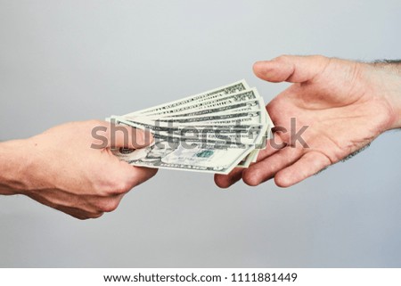 Business closeup of two hands exchanging dollars on grey background. 