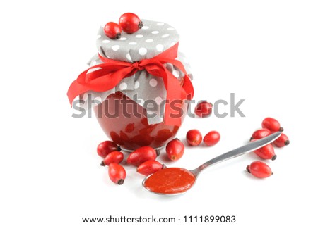 Rose hip jam and spoon with jam on white background