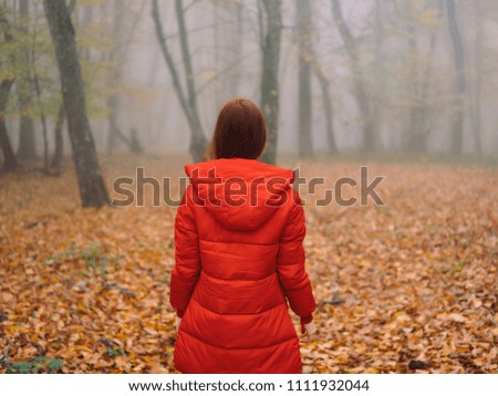 woman in a red jacket in a forest yellow autumn nature
