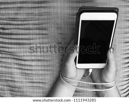 Close up women hand holding Mobile phone with rope Bind hand , A concept about loneliness within social media, bad social in mobile phone