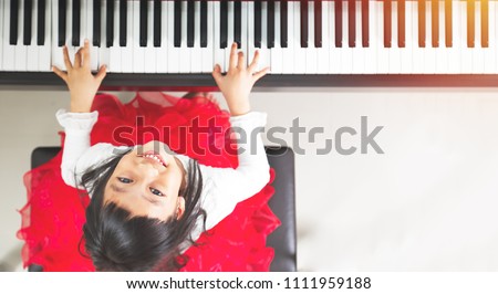 Little asian girl happy to play piano