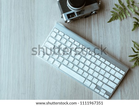  Keyboard , and camera Leaves  on  desk office wooden