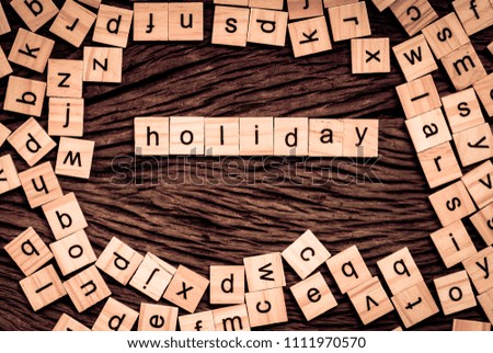 Holiday word written cube on wooden background. Vintage concept.