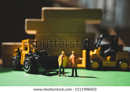 Miniature people, couple workers standing at warehouse using as logistic and industry concept