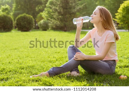 girl on the lawn drinking water
