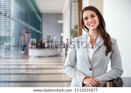 Smiling likable sincere and charming business woman financial executive type portrait inside commercial building Royalty-Free Stock Photo #1112035877