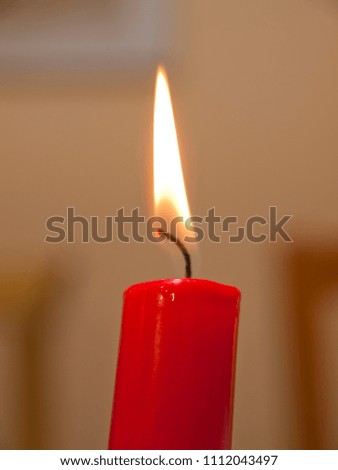 Red Candle lit in calm over blurred background