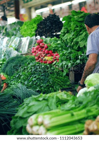 greens, vegetables, onions, radish, celery, mint are sold on the market. the layout of the greenery on the table. seller. Royalty-Free Stock Photo #1112043653