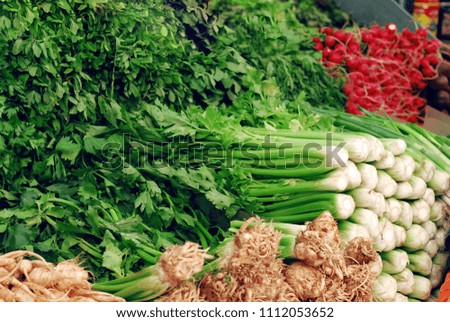 greens, vegetables, onions, radish, celery, mint are sold on the market. the layout of the greenery on the table Royalty-Free Stock Photo #1112053652