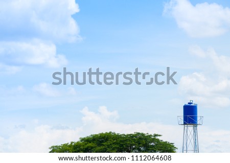 A plastic blue water tank on the tower in park