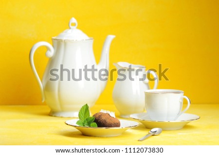 Tea, tea and pastries with mint leaves on a yellow background