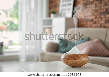 Aroma oil diffuser on table at home. Air freshener Royalty-Free Stock Photo #1112081108