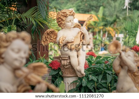 Cupid playing golden guitar statue