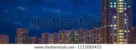 Glowing windows of houses against the background of the night sky Banner concept