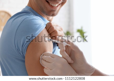 Doctor vaccinating male patient in clinic, closeup Royalty-Free Stock Photo #1112122808