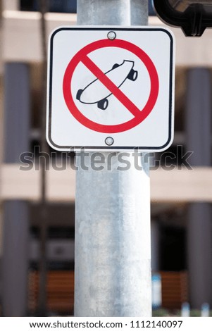 No skateboarding sign on a city lamp post, with space for text on bottom