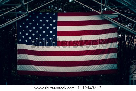 American flag hanging from rafters, Dark Background. 
