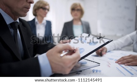 Firm workers studying and analyzing supply and demand statistic on world market Royalty-Free Stock Photo #1112145491