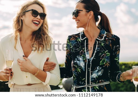 Beautiful women walking and talking outdoors. Best friends having a great time together. Royalty-Free Stock Photo #1112149178