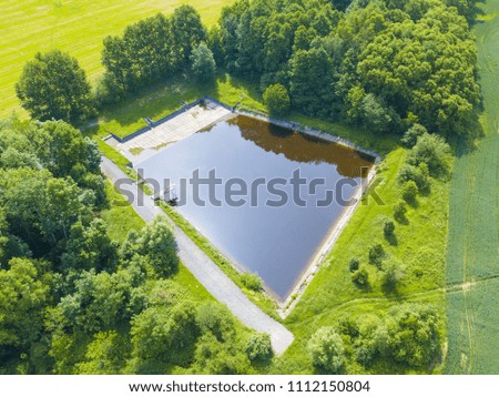 Aerial view of public outdoor swimming pool in nature ready to summer season.
