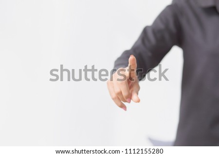 The woman touches the imaginary screen with her finger. On a white background and space for ideas.