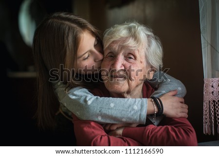 A little girl hugs her grandmother. Royalty-Free Stock Photo #1112166590