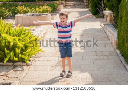 Happy cute Caucasian child with hands open as if wanting to embrace someone.
