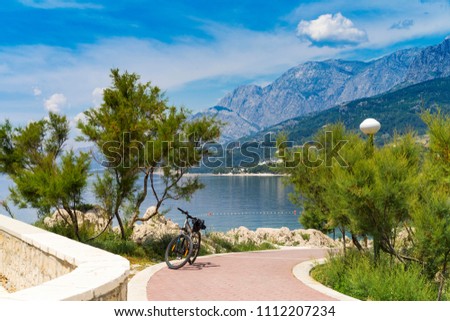Beautiful sunny day in Makarska Croatia Europe, Nice outdoors of the popular tourist city in Dalmatia. Bicycle, Adriatic Sea and Mountains. Calm, peaceful and happy photo.