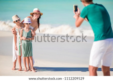 Family taking a photo on their beach holidays. Family beach vacation