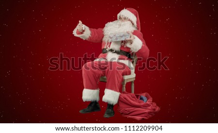 Santa makes selfie with smartphone on red background with snow